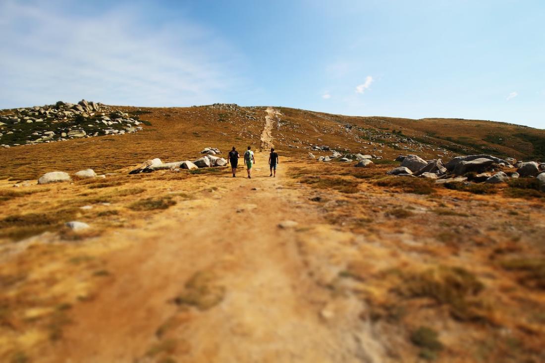 Trois hommes marchent sur un chemin de terre en Corse